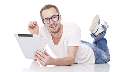 young man using tablet computer and lying on the floor