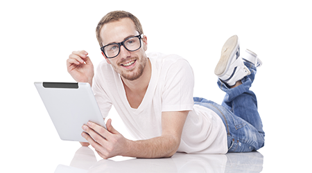 young man using tablet computer and lying on the floor